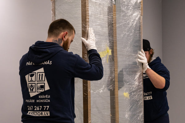 AVECTOR Group movers carefully wrapping and transporting furniture during a relocation.