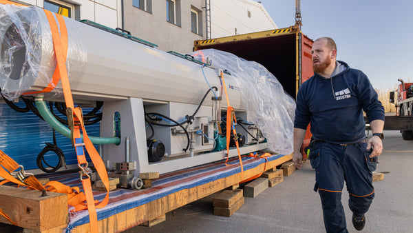 Avector employee next to a big piece of machinery 